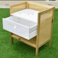 Mesa de noche auxiliar beige estilo boho con cajón blanco y paneles laterales de rejilla